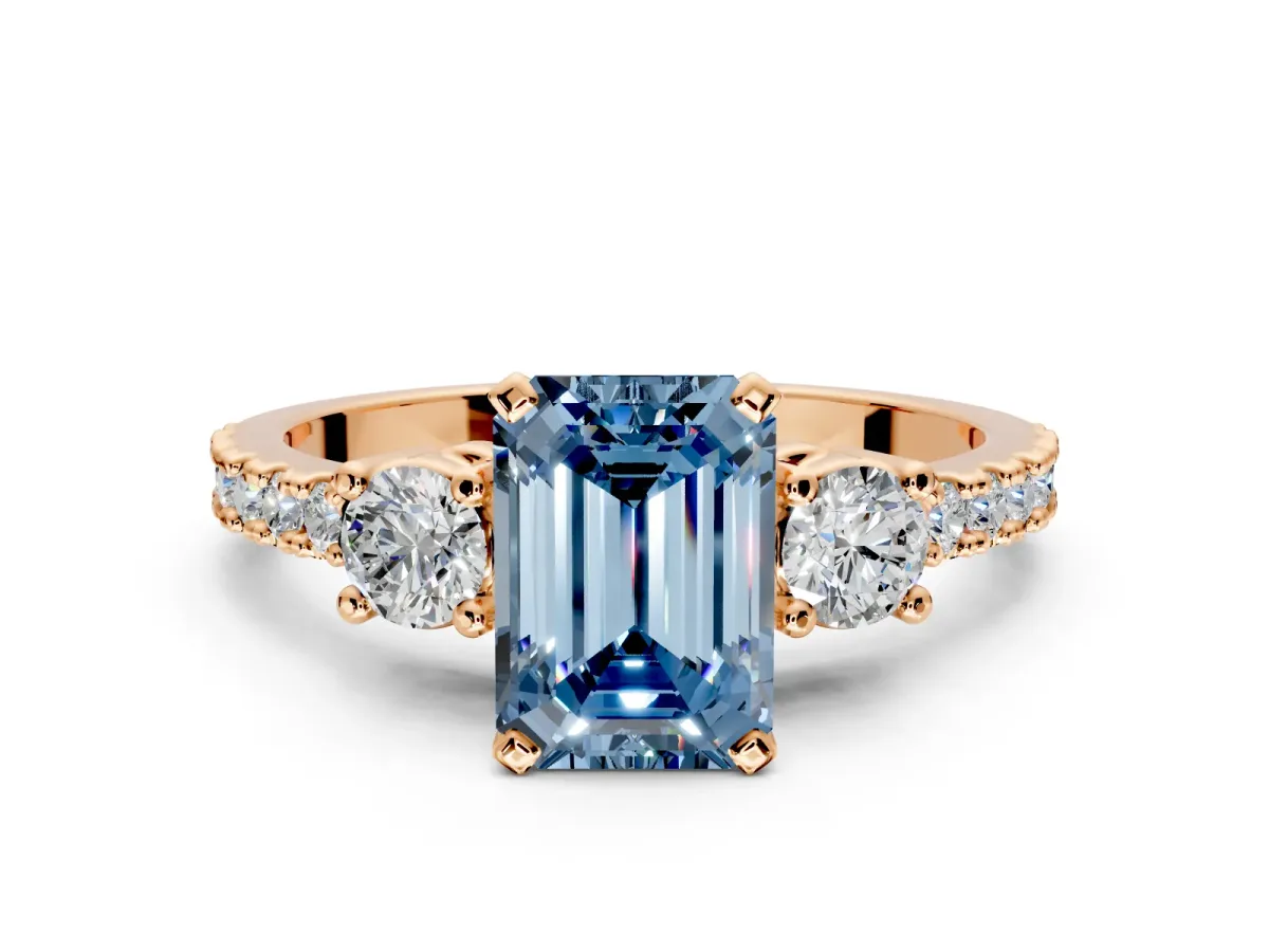 3 Stone Engagement Ring Setting for Fancy Blue Emerald Cut Center with Round Cut Side Accents and Prong Head in Rose Gold