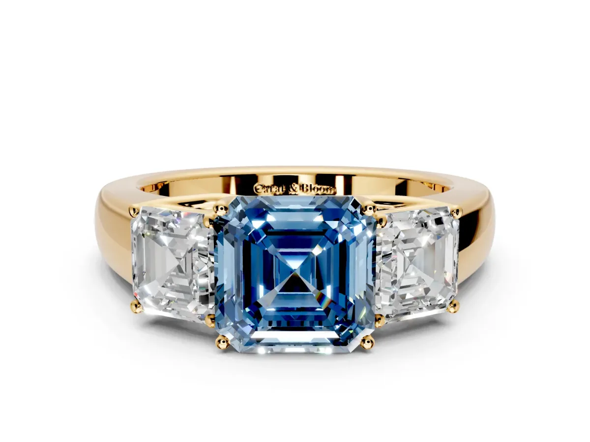3 Stone Engagement Ring Setting for Fancy Blue Asscher Cut Center with Raised Basket Heads and Prong Head in Yellow Gold