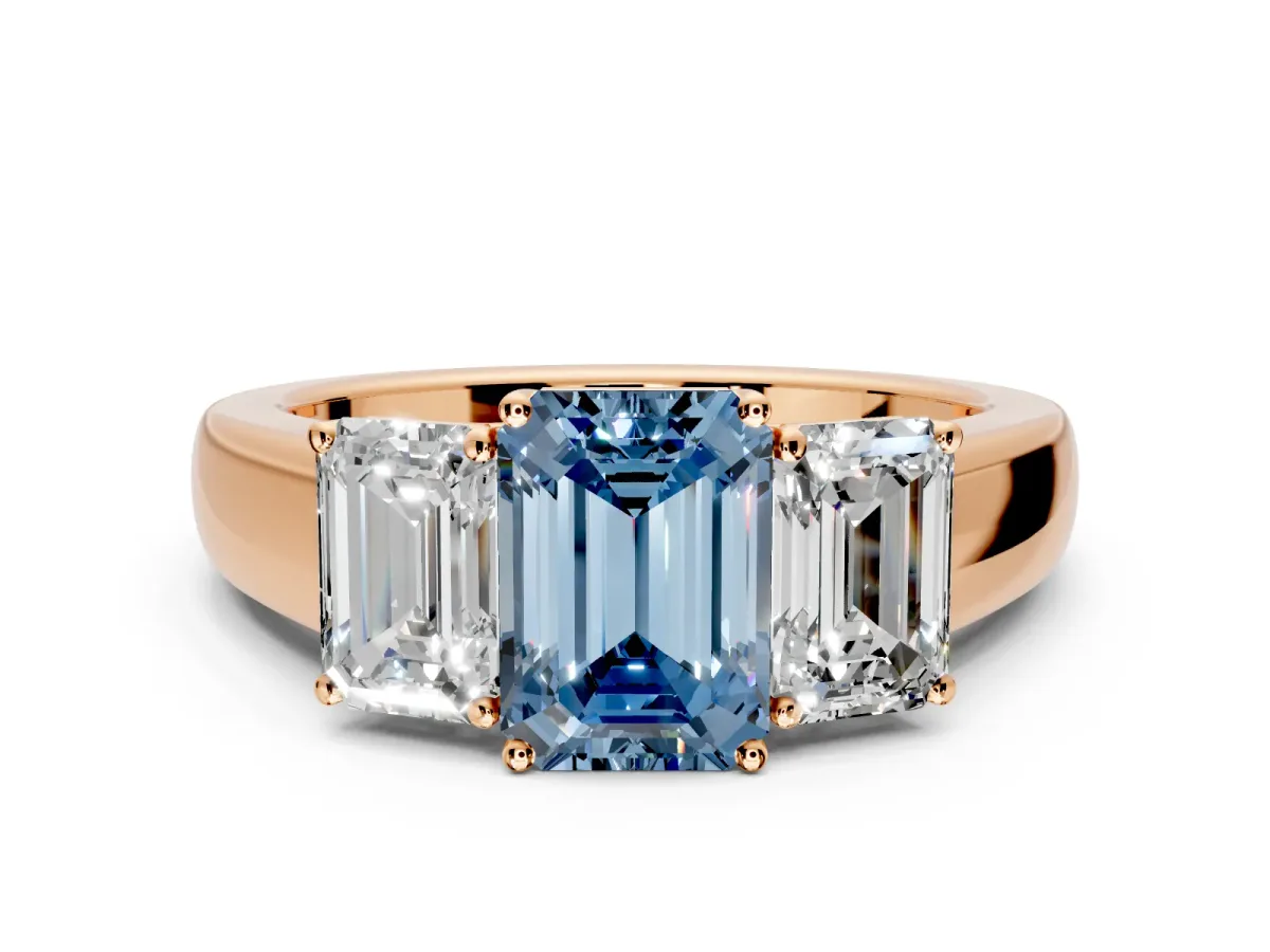 3 Stone Engagement Ring Setting for Fancy Blue Emerald Cut Center with Raised Basket Heads and Prong Head in Rose Gold