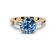 3 Stone Engagement Ring Setting for Fancy Blue Round Cut Center with Channel Baguette Accents and Prong Head in Yellow Gold