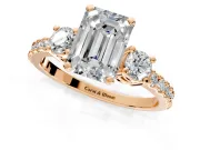 3 Stone Engagement Ring Setting for Emerald Cut Center with Round Cut Side Accents and Prong Head in Rose Gold