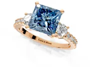 3 Stone Engagement Ring Setting for Fancy Blue Princess Cut Center with Round Cut Side Accents and Prong Head in Rose Gold