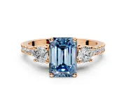 3 Stone Engagement Ring Setting for Fancy Blue Emerald Cut Center with Round Cut Side Accents and Prong Head in Rose Gold