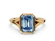 Solitaire Engagement Ring Setting for Fancy Blue Emerald Cut Center with V Split Shank and Bezel Head in Yellow Gold
