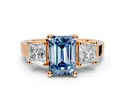 3 Stone Engagement Ring Setting for Fancy Blue Emerald Cut Center with Matching Side Accents and Prong Head in Rose Gold