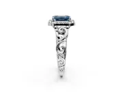 Halo Engagement Ring Setting for Fancy Blue Emerald Cut Center with Open Scroll Shoulders and Prong Head in Platinum