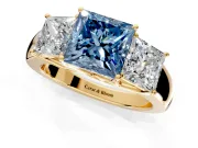 3 Stone Engagement Ring Setting for Fancy Blue Princess Cut Center with Raised Basket Heads and Prong Head in Yellow Gold