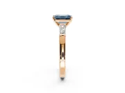 3 Stone Engagement Ring Setting for Fancy Blue Emerald Cut Center with Tapered Baguettes, Plain Band and Prong Head in Rose Gold