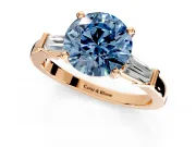 3 Stone Engagement Ring Setting for Fancy Blue Round Cut Center with Channel Baguette Accents and Prong Head in Rose Gold