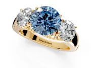 3 Stone Engagement Ring Setting for Fancy Blue Round Cut Center with Raised Basket Heads and Prong Head in Yellow Gold
