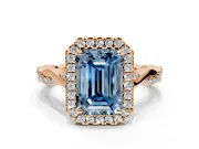 Halo Engagement Ring Setting for Fancy Blue Emerald Cut Center with Twist Band and Prong Head in Rose Gold