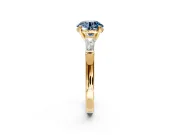 3 Stone Engagement Ring Setting for Fancy Blue Round Cut Center with Tapered Baguettes, Plain Band and Prong Head in Yellow Gold