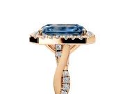 Halo Engagement Ring Setting for Fancy Blue Emerald Cut Center with Twist Band and Prong Head in Rose Gold