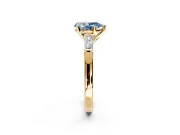 3 Stone Engagement Ring Setting for Fancy Blue Pear-Shaped Center with Tapered Baguettes, Plain Band and Prong Head in Yellow Gold