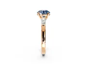 3 Stone Engagement Ring Setting for Fancy Blue Round Cut Center with Tapered Baguettes, Plain Band and Prong Head in Rose Gold