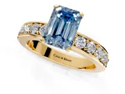 Solitaire Engagement Ring Setting for Fancy Blue Emerald Cut Center with Channel-Set Accents and Prong Head in Yellow Gold