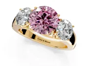 3 Stone Engagement Ring Setting for Fancy Pink Round Cut Center with Raised Basket Heads and Prong Head in Yellow Gold